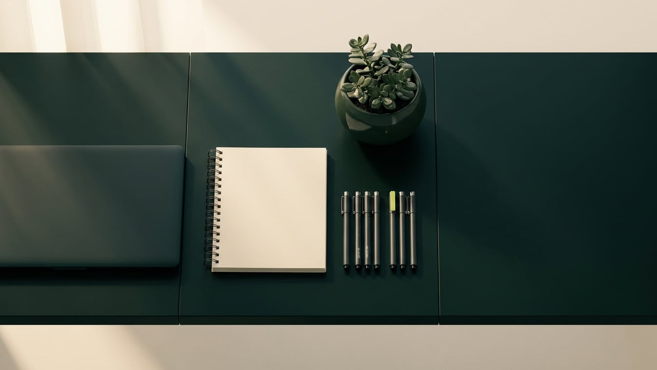 Tidy desk from above with drafting pens and a notebook