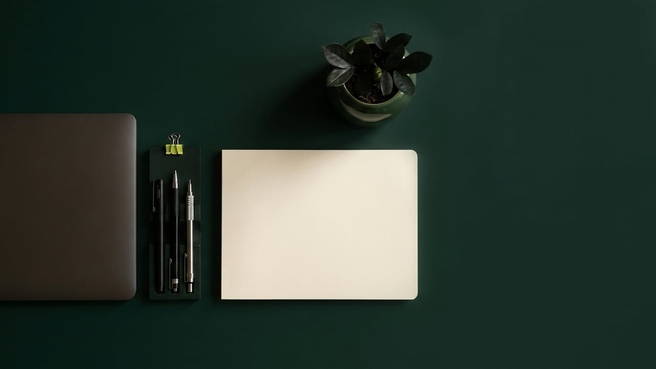 Tidy desk from above with drafting pens and a notebook